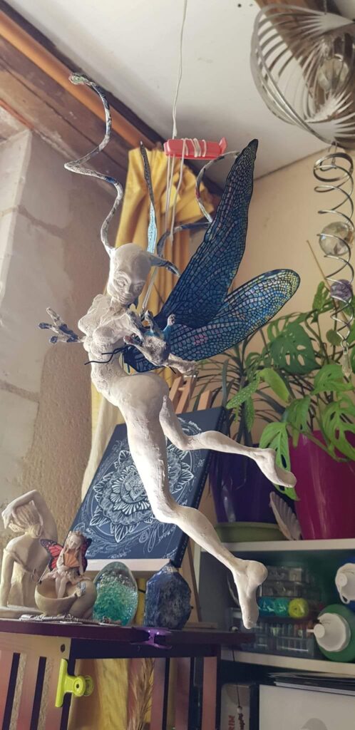 Sculpture suspendue, en cours, d'un personnage hybride, mi fée, mi-insectoïde. Expérimentation de technique-mixte faite "maison" pour cette réalisation.